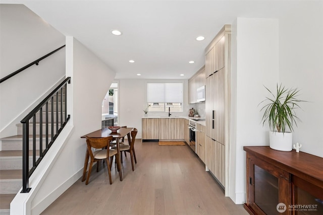 4303 Dayton Ave N Unit E, Seattle, WA 98103 - kitchen with white microwave, modern cabinets, recessed lighting, light wood-style floors, and light countertops