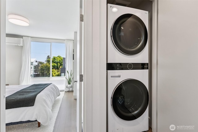 4303 Dayton Ave N Unit E, Seattle, WA 98103 - laundry area with stacked washer / drying machine, a wall mounted AC, and wood finished floors