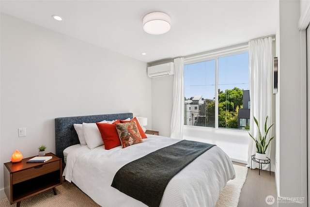 4303 Dayton Ave N Unit E, Seattle, WA 98103 - bedroom featuring an AC wall unit, wood finished floors, and recessed lighting