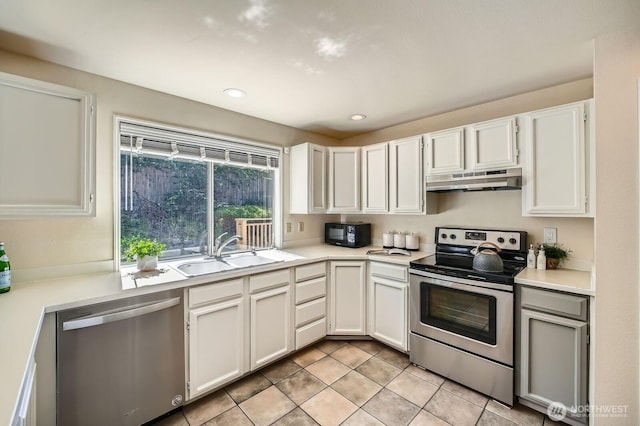 34427 10th Ave SW, Federal Way, WA 98023 - kitchen with appliances with stainless steel finishes, under cabinet range hood, light countertops, white cabinetry, and recessed lighting