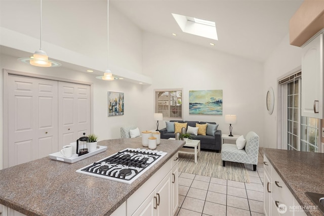 8612 218th St SW, Edmonds, WA 98026 - kitchen with white gas cooktop, light tile patterned floors, a skylight, white cabinets, and high vaulted ceiling