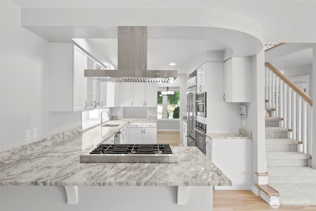 3505 W 43rd Ave, Seattle, WA 98199 - kitchen with stainless steel appliances, island exhaust hood, light wood-style floors, a peninsula, and white cabinets