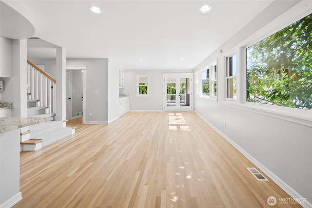 3505 W 43rd Ave, Seattle, WA 98199 - unfurnished living room featuring french doors, stairs, light wood-style flooring, and recessed lighting