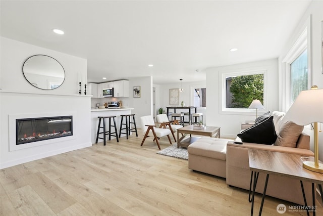 12448 Occidental Ave S, Seattle, WA 98168 - living room with light wood-style flooring, a glass covered fireplace, and recessed lighting