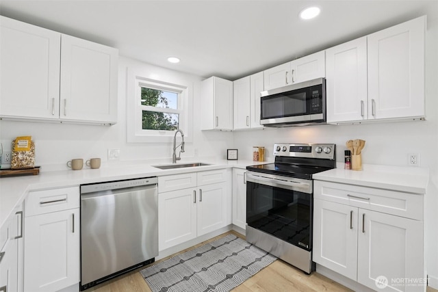 12448 Occidental Ave S, Seattle, WA 98168 - kitchen with stainless steel appliances, white cabinets, light wood finished floors, light countertops, and recessed lighting