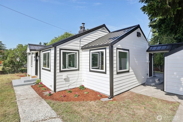 12448 Occidental Ave S, Seattle, WA 98168 - view of property exterior with a standing seam roof, a metal roof, and a yard