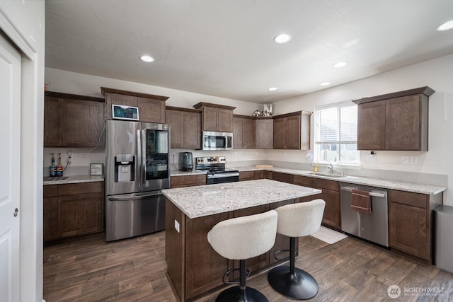4211 W Heaverlo Dr, Moses Lake, WA 98837 - kitchen with appliances with stainless steel finishes, a kitchen island, dark wood-style floors, dark brown cabinets, and recessed lighting