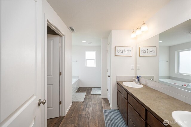 4211 W Heaverlo Dr, Moses Lake, WA 98837 - full bath featuring a bath, double vanity, wood finished floors, and recessed lighting