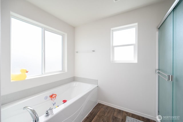 4211 W Heaverlo Dr, Moses Lake, WA 98837 - bathroom featuring plenty of natural light, a garden tub, wood finished floors, and an enclosed shower
