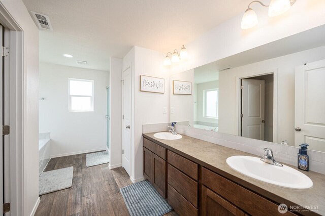 4211 W Heaverlo Dr, Moses Lake, WA 98837 - full bath featuring wood finished floors, double vanity, plenty of natural light, and a garden tub
