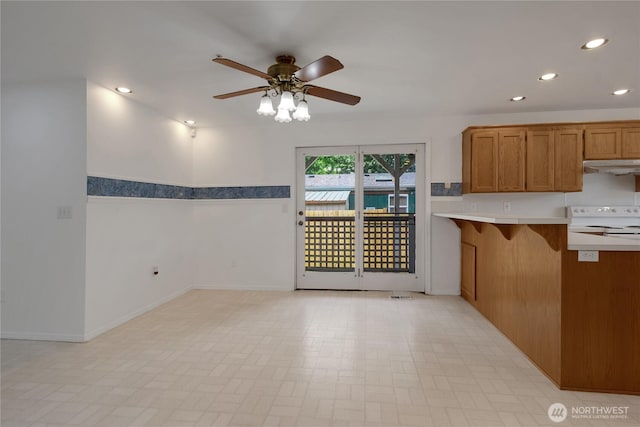 19517 Whiteman Cove Rd SW, Longbranch, WA 98351 - kitchen with under cabinet range hood, a ceiling fan, recessed lighting, brown cabinets, and white range with electric cooktop
