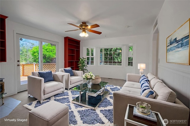 19517 Whiteman Cove Rd SW, Longbranch, WA 98351 - living area with ceiling fan, built in shelves, and a wainscoted wall