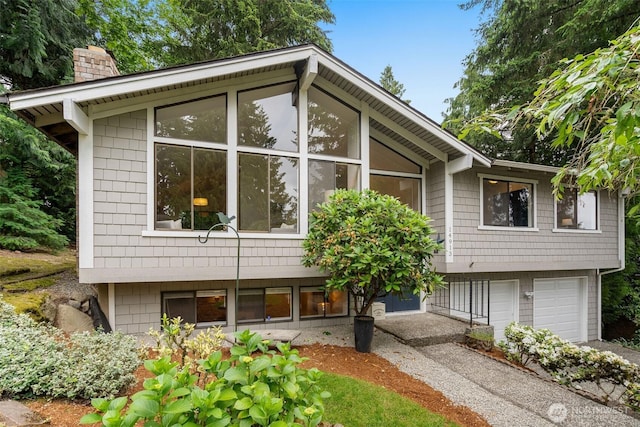 14913 SE 47th Ct, Bellevue, WA 98006 - view of property exterior featuring a chimney, an attached garage, and driveway