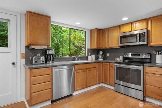 14913 SE 47th Ct, Bellevue, WA 98006 - kitchen with stainless steel appliances, light wood-style floors, plenty of natural light, dark countertops, and recessed lighting