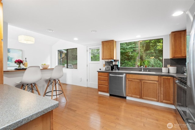 14913 SE 47th Ct, Bellevue, WA 98006 - kitchen featuring stainless steel dishwasher, stove, healthy amount of natural light, brown cabinets, and recessed lighting