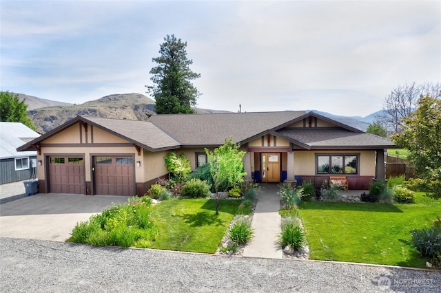 512 May St, Twisp, WA 98856 - view of front of property featuring an attached garage, concrete driveway, a front yard, and a mountain view