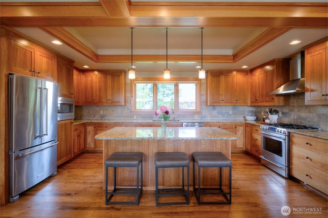 512 May St, Twisp, WA 98856 - kitchen featuring high quality appliances, wall chimney exhaust hood, a raised ceiling, ornamental molding, and a center island