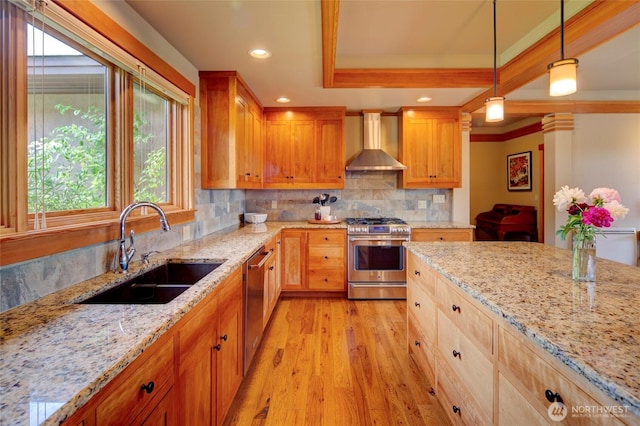 512 May St, Twisp, WA 98856 - kitchen featuring stainless steel appliances, wall chimney exhaust hood, plenty of natural light, ornamental molding, and light wood-style flooring