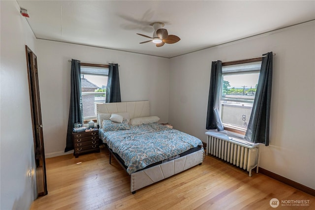 801 Martin Luther King Jr Way, Tacoma, WA 98405 - bedroom featuring radiator, multiple windows, light wood-style floors, and a ceiling fan