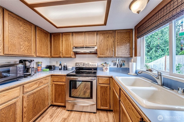 1722 172nd St SE, Bothell, WA 98012 - kitchen with stainless steel range with electric cooktop, under cabinet range hood, light countertops, and light wood finished floors