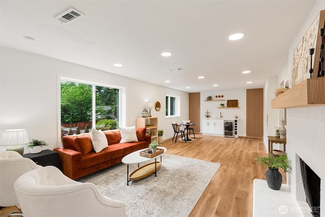 331 137th St SW, Everett, WA 98208 - living room with beverage cooler, light wood-style flooring, bar with sink, recessed lighting, and a fireplace