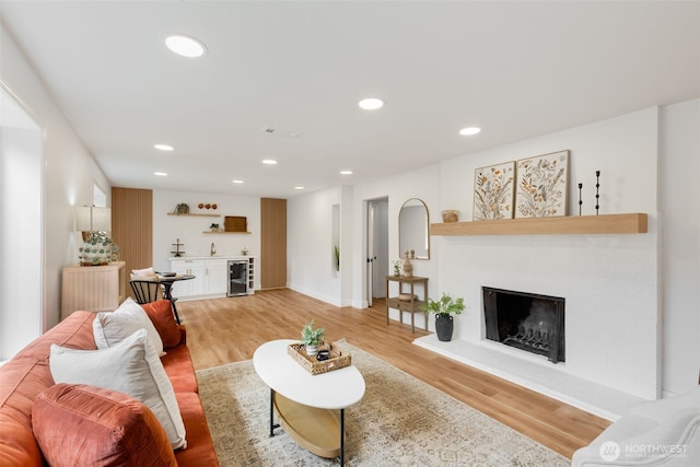 331 137th St SW, Everett, WA 98208 - living area featuring wet bar, beverage cooler, light wood finished floors, a fireplace with raised hearth, and recessed lighting