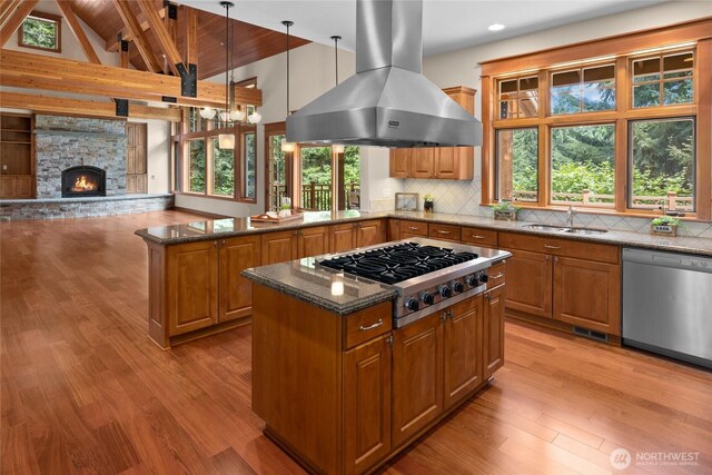 141 Just In Time Ln, Cle Elum, WA 98922 - kitchen with appliances with stainless steel finishes, island exhaust hood, brown cabinetry, dark stone countertops, and beam ceiling