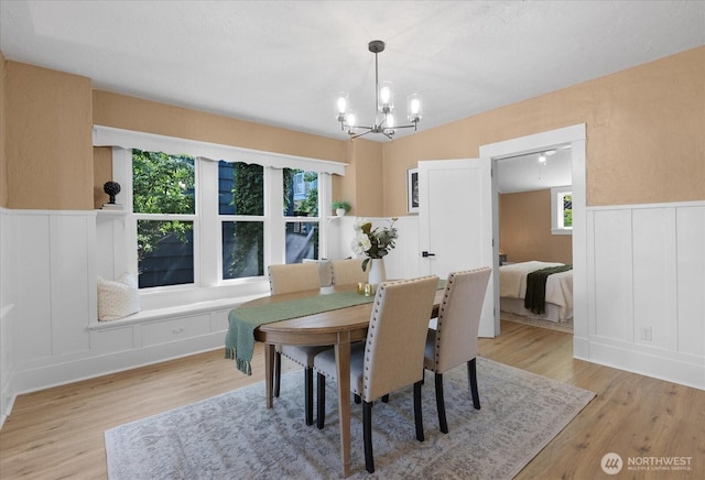 3443 21st Ave W, Seattle, WA 98199 - dining room with a chandelier, light wood finished floors, a decorative wall, healthy amount of natural light, and a wainscoted wall