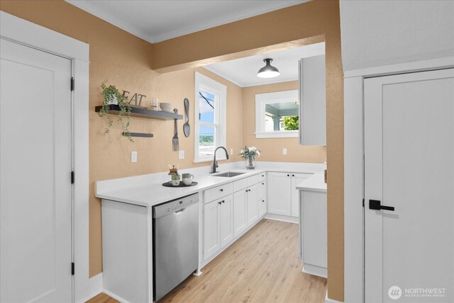 3443 21st Ave W, Seattle, WA 98199 - kitchen featuring stainless steel dishwasher, light wood-style floors, white cabinetry, light countertops, and crown molding