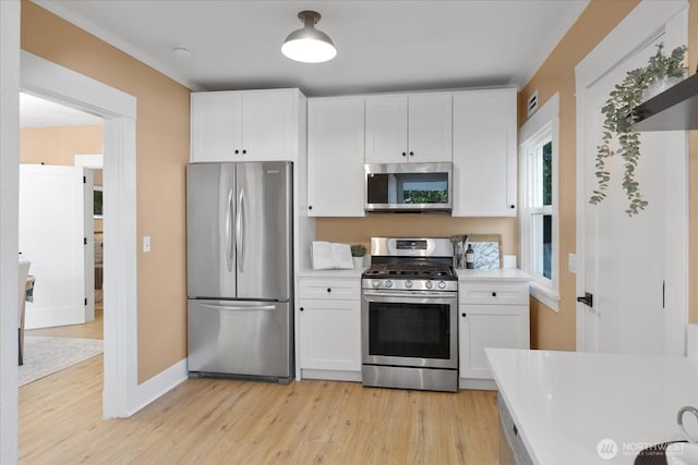3443 21st Ave W, Seattle, WA 98199 - kitchen featuring stainless steel appliances, light countertops, white cabinetry, and light wood-style floors