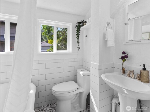 3443 21st Ave W, Seattle, WA 98199 - full bath featuring tile walls, tile patterned flooring, wainscoting, and shower / tub combo with curtain
