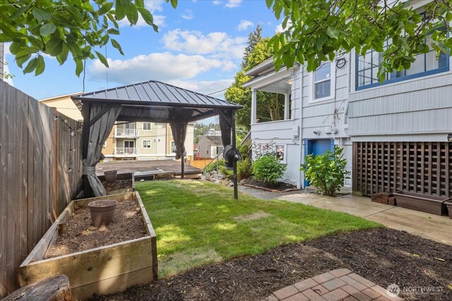 3443 21st Ave W, Seattle, WA 98199 - fenced backyard featuring a gazebo and a vegetable garden