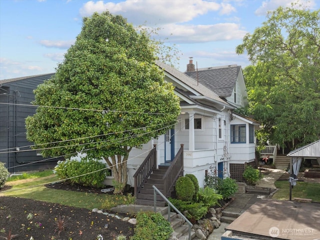 3443 21st Ave W, Seattle, WA 98199 - view of front of property featuring stairs, roof with shingles, and a chimney