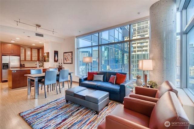 2033 2nd Ave Unit 1608, Seattle, WA 98121 - living room with expansive windows, light wood-type flooring, healthy amount of natural light, and rail lighting