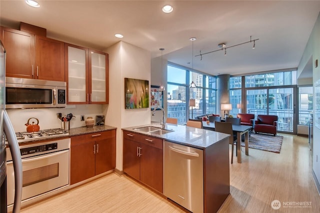2033 2nd Ave Unit 1608, Seattle, WA 98121 - kitchen featuring stainless steel appliances, a peninsula, rail lighting, open floor plan, and dark stone countertops
