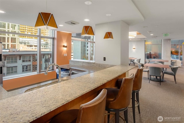 2033 2nd Ave Unit 1608, Seattle, WA 98121 - kitchen with carpet, stone counters, recessed lighting, and decorative light fixtures