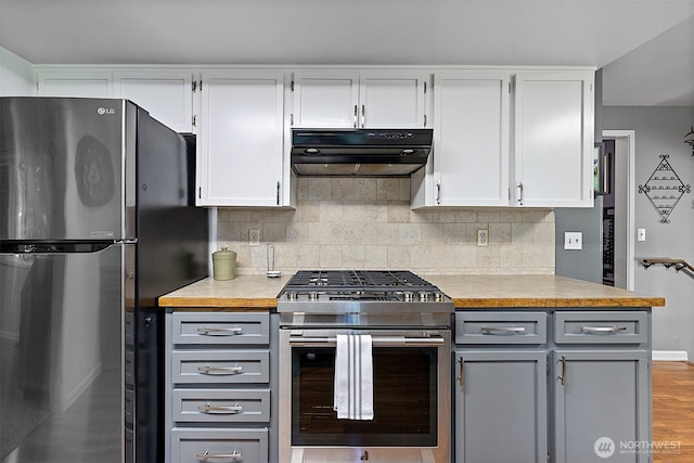 856 Island Blvd, Fox Island, WA 98333 - kitchen with stainless steel appliances, under cabinet range hood, gray cabinets, light countertops, and decorative backsplash