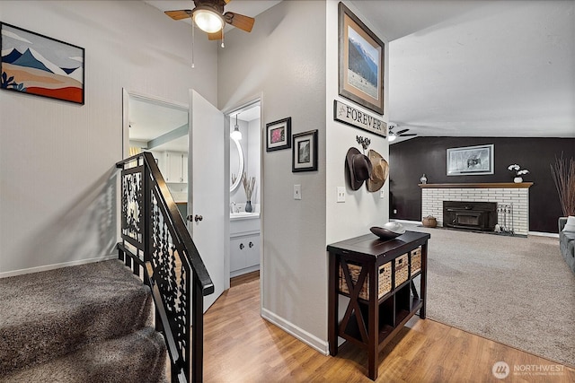 856 Island Blvd, Fox Island, WA 98333 - stairway with ceiling fan, vaulted ceiling, a fireplace, wood finished floors, and carpet