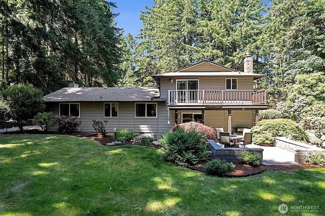 856 Island Blvd, Fox Island, WA 98333 - back of property featuring a chimney, a balcony, a patio, a yard, and an attached garage