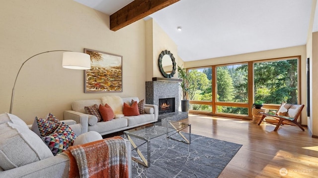 9623 NE Riverbend Dr Unit 2B, Bothell, WA 98011 - living area featuring wood finished floors, beam ceiling, a lit fireplace, and high vaulted ceiling