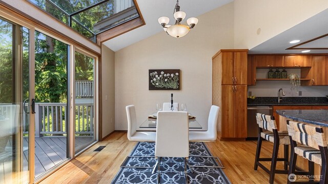 9623 NE Riverbend Dr Unit 2B, Bothell, WA 98011 - dining room featuring light wood-type flooring, a chandelier, bar with sink, recessed lighting, and high vaulted ceiling