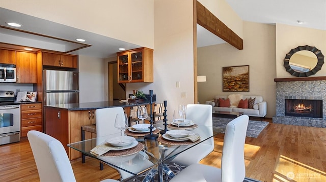 9623 NE Riverbend Dr Unit 2B, Bothell, WA 98011 - dining space with light wood-type flooring, recessed lighting, a brick fireplace, and high vaulted ceiling