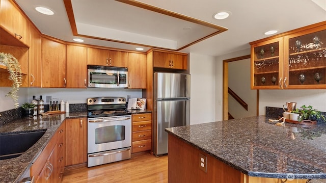 9623 NE Riverbend Dr Unit 2B, Bothell, WA 98011 - kitchen featuring appliances with stainless steel finishes, recessed lighting, light wood-style flooring, brown cabinetry, and glass insert cabinets