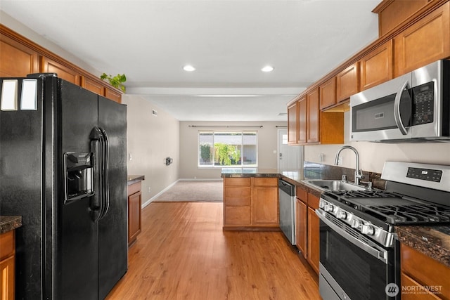 19436 SE 266th St, Covington, WA 98042 - kitchen with appliances with stainless steel finishes, brown cabinetry, dark countertops, and recessed lighting