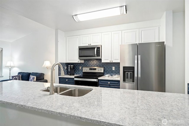 901 E Marine View Dr Unit 206, Everett, WA 98201 - kitchen with stainless steel appliances, decorative backsplash, white cabinets, open floor plan, and blue cabinetry
