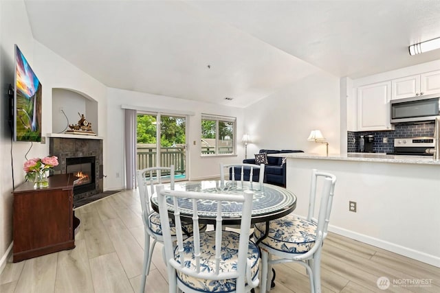 901 E Marine View Dr Unit 206, Everett, WA 98201 - dining room featuring light wood-style flooring and a tile fireplace