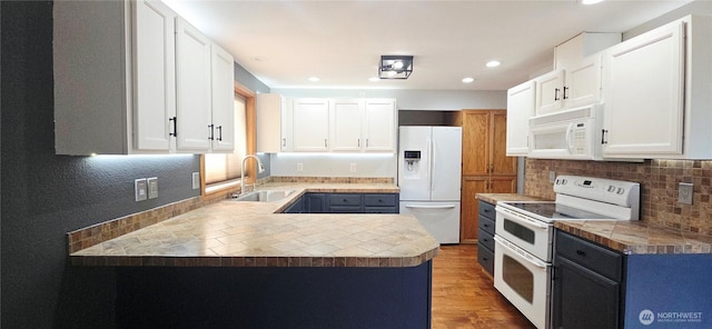 5903 187th Ave SW, Rochester, WA 98579 - kitchen featuring white appliances, backsplash, wood finished floors, a peninsula, and white cabinets