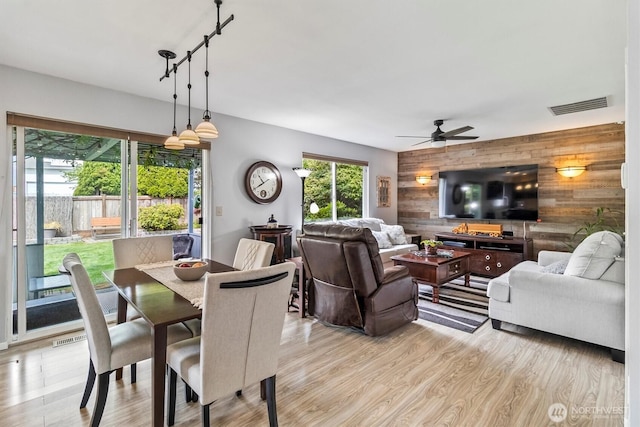 1606 94th Ave NE, Lake Stevens, WA 98258 - dining area with wood walls, an accent wall, ceiling fan, and light wood-type flooring