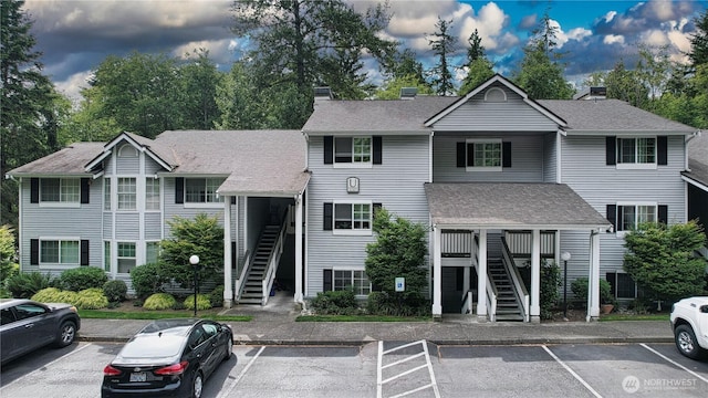 23301 Cedar Way Unit U102, Mountlake Terrace, WA 98043 - view of front facade with stairs, a chimney, and uncovered parking