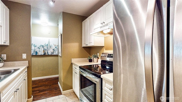 23301 Cedar Way Unit U102, Mountlake Terrace, WA 98043 - kitchen with under cabinet range hood, appliances with stainless steel finishes, light countertops, and white cabinets